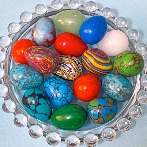 colourful gemstone stone eggs on a clear glass plate