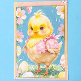 postcard of a cute yellow chick with flowers and Easter eggs on a blue background