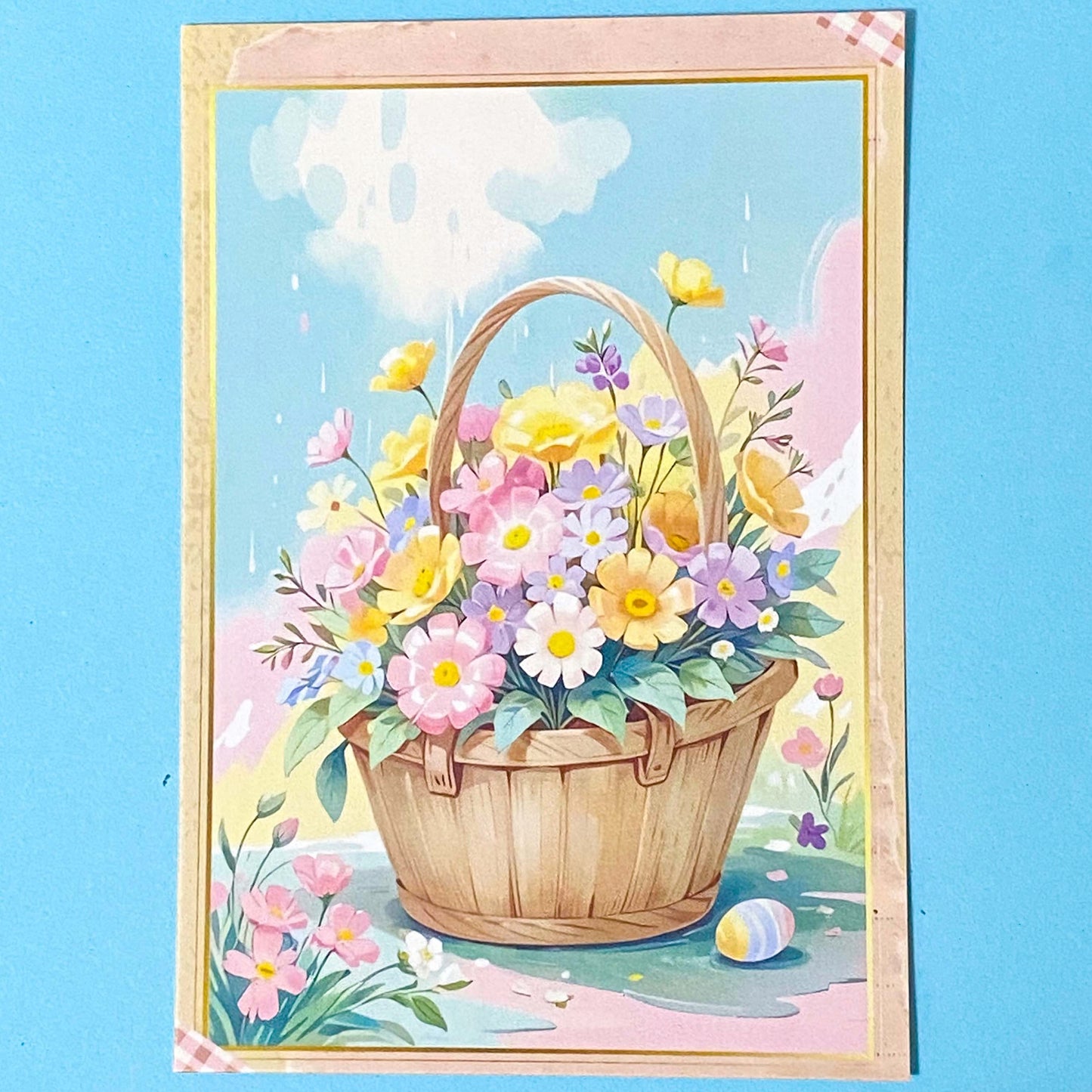 postcard of a spring basket of flowers with a blue background