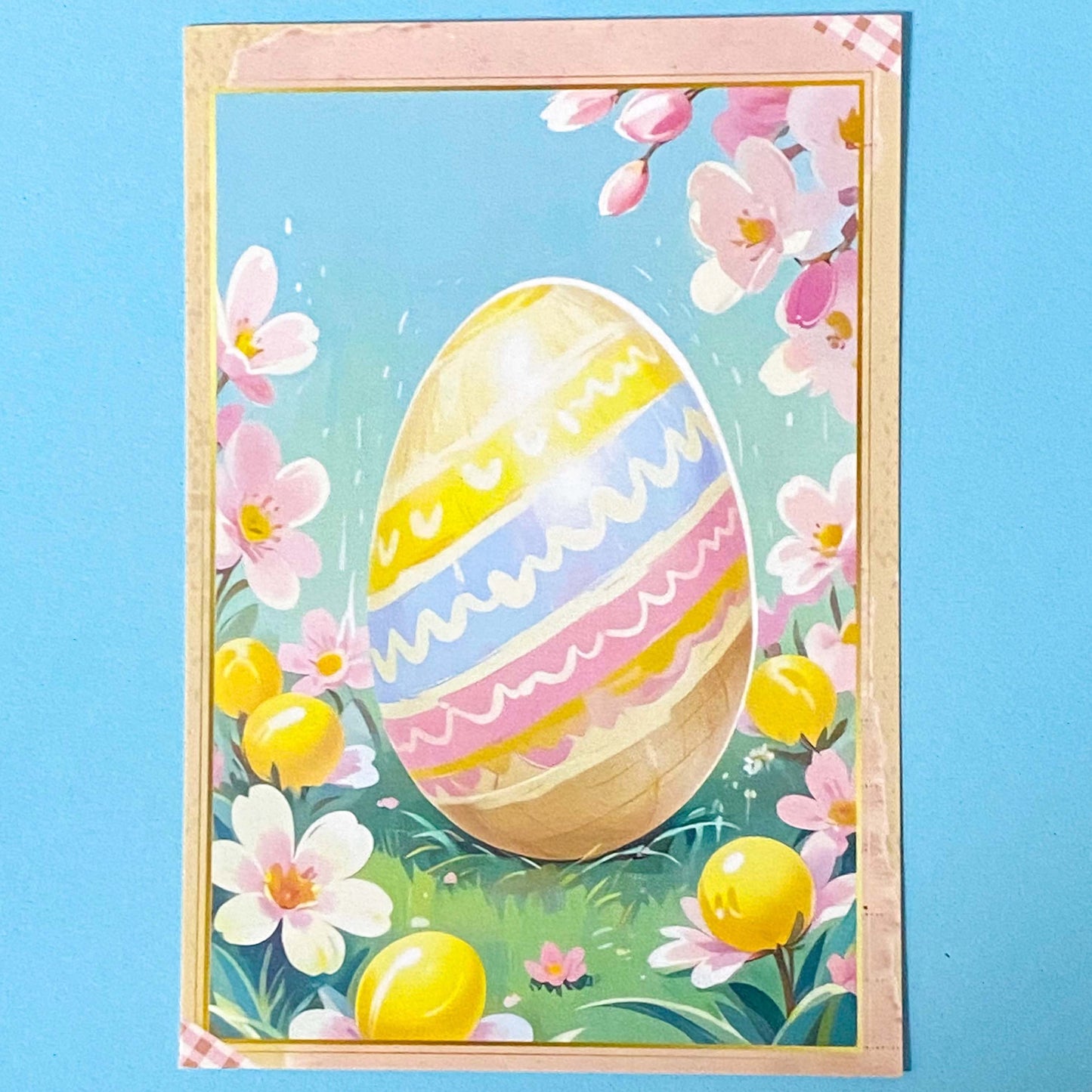 Easter-themed postcard with a colourful egg and flowers on a blue background