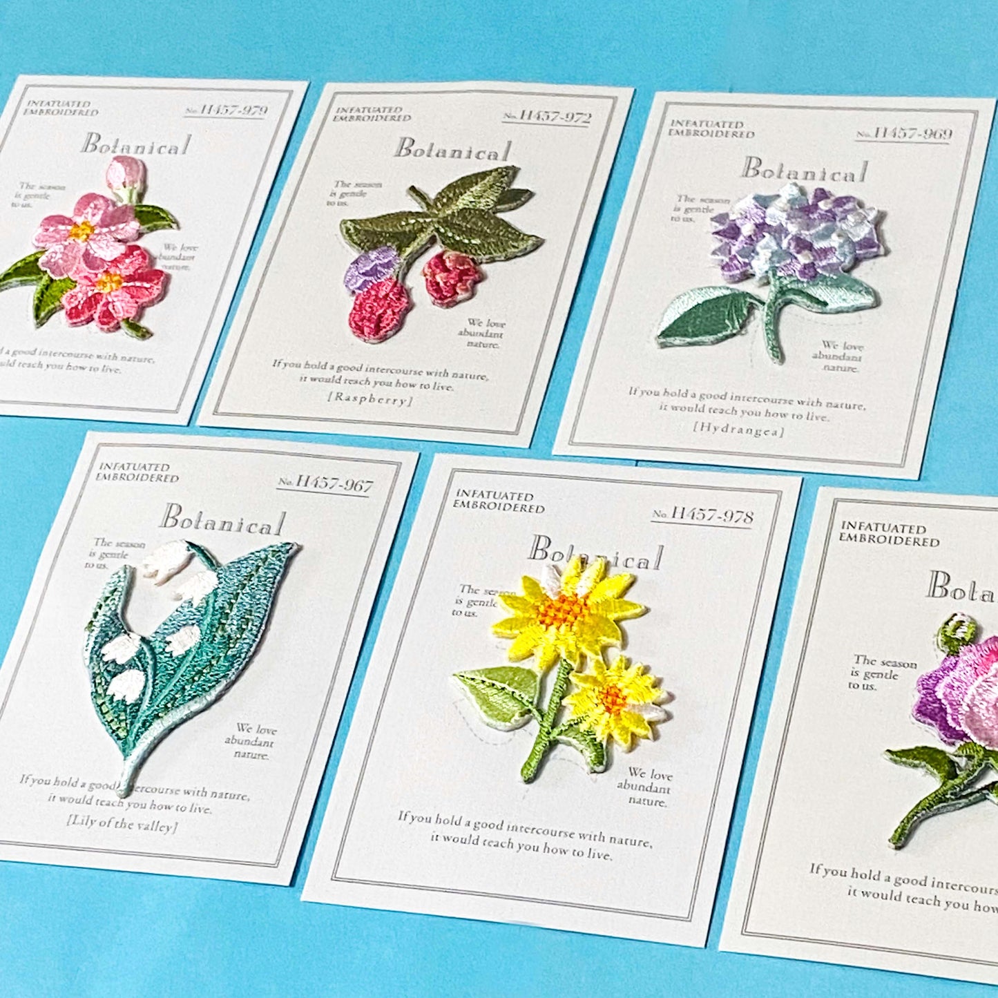 botanical embroidery patches of flowers on white cards on a blue background