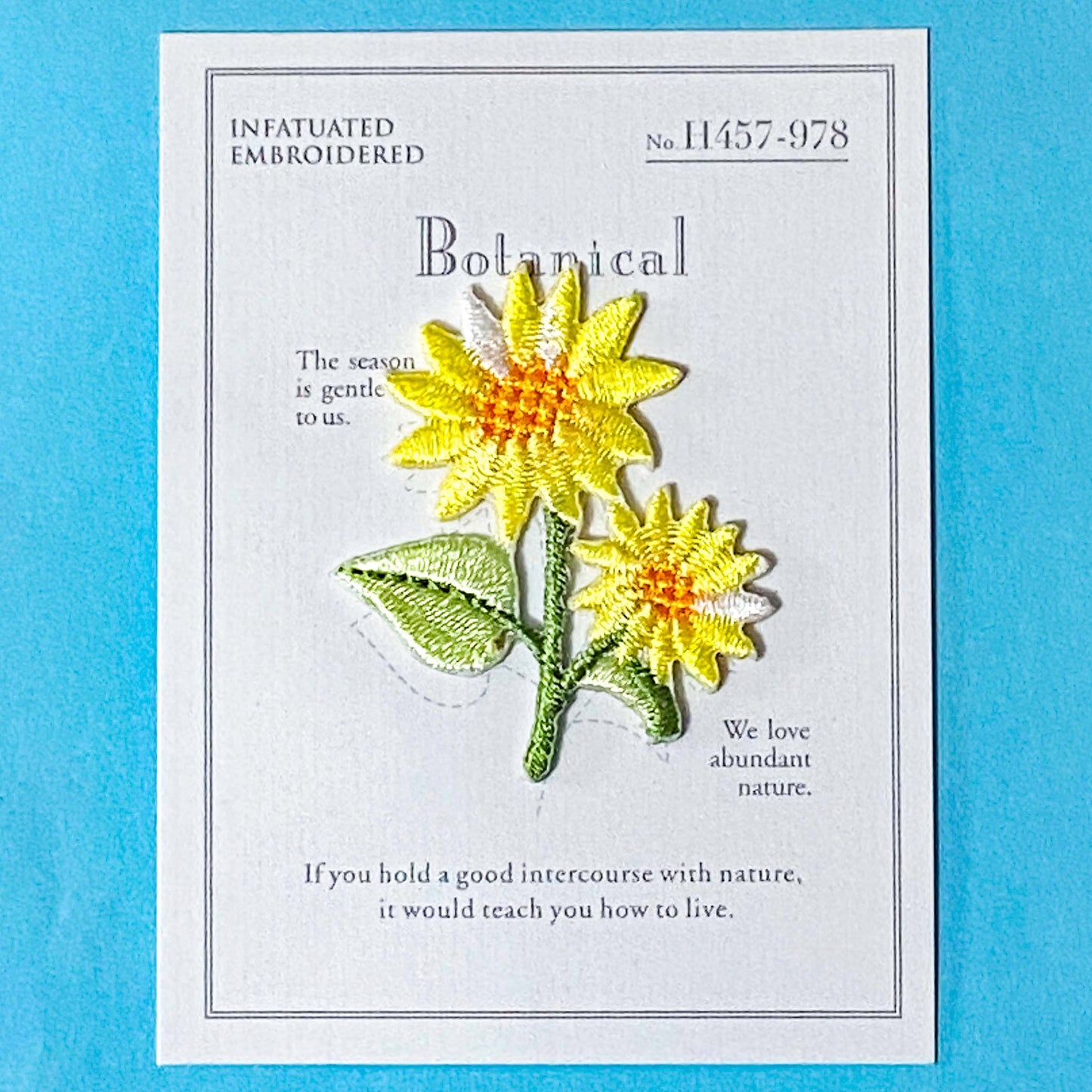 yellow daisy embroidery iron on patch on a blue background