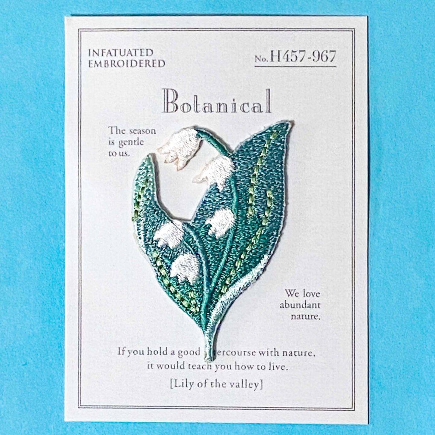 lily of the valley flower embroidery iron on patch on a blue background