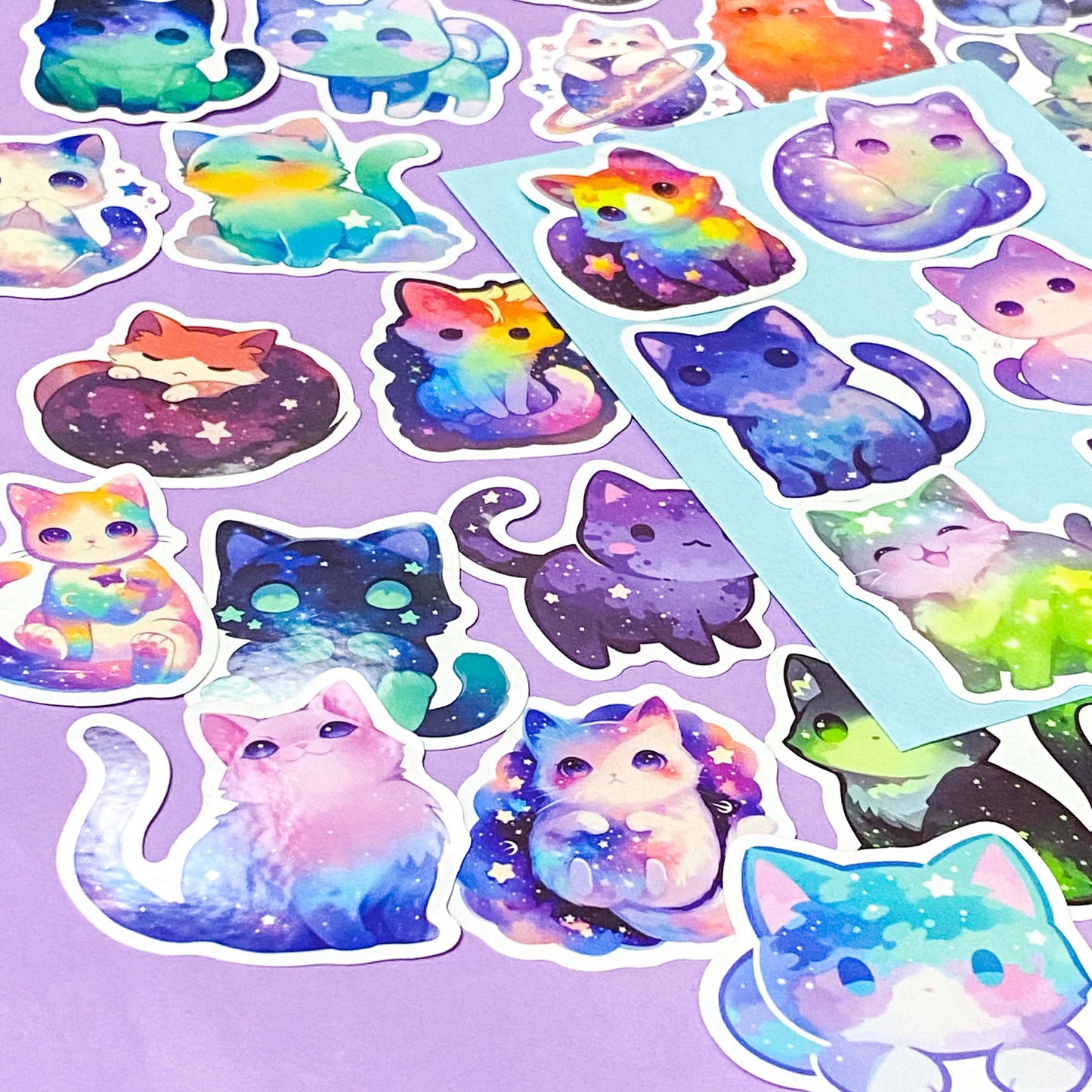 Colorful cat-shaped stickers with galaxy design on a purple background