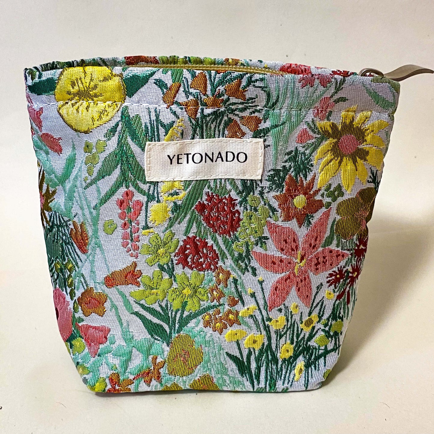 premium woven green, peach and yellow wild flower tapestry small bucket pouch with cream lining and concealed zip. Uk letterbox gifts. Botanical cosmetic bag.