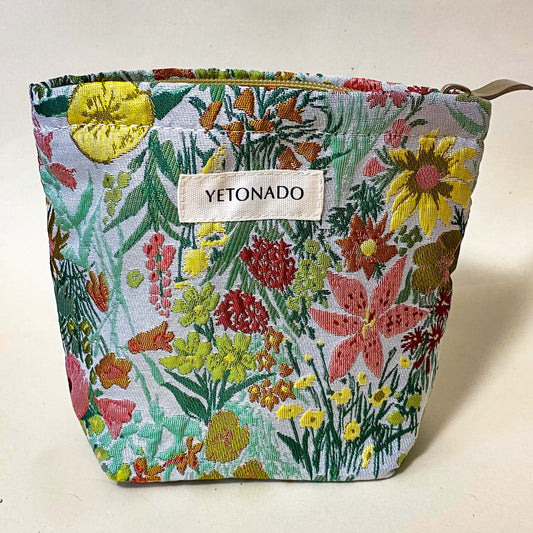 premium woven green, peach and yellow wild flower tapestry small bucket pouch with cream lining and concealed zip. Uk letterbox gifts. Botanical cosmetic bag.