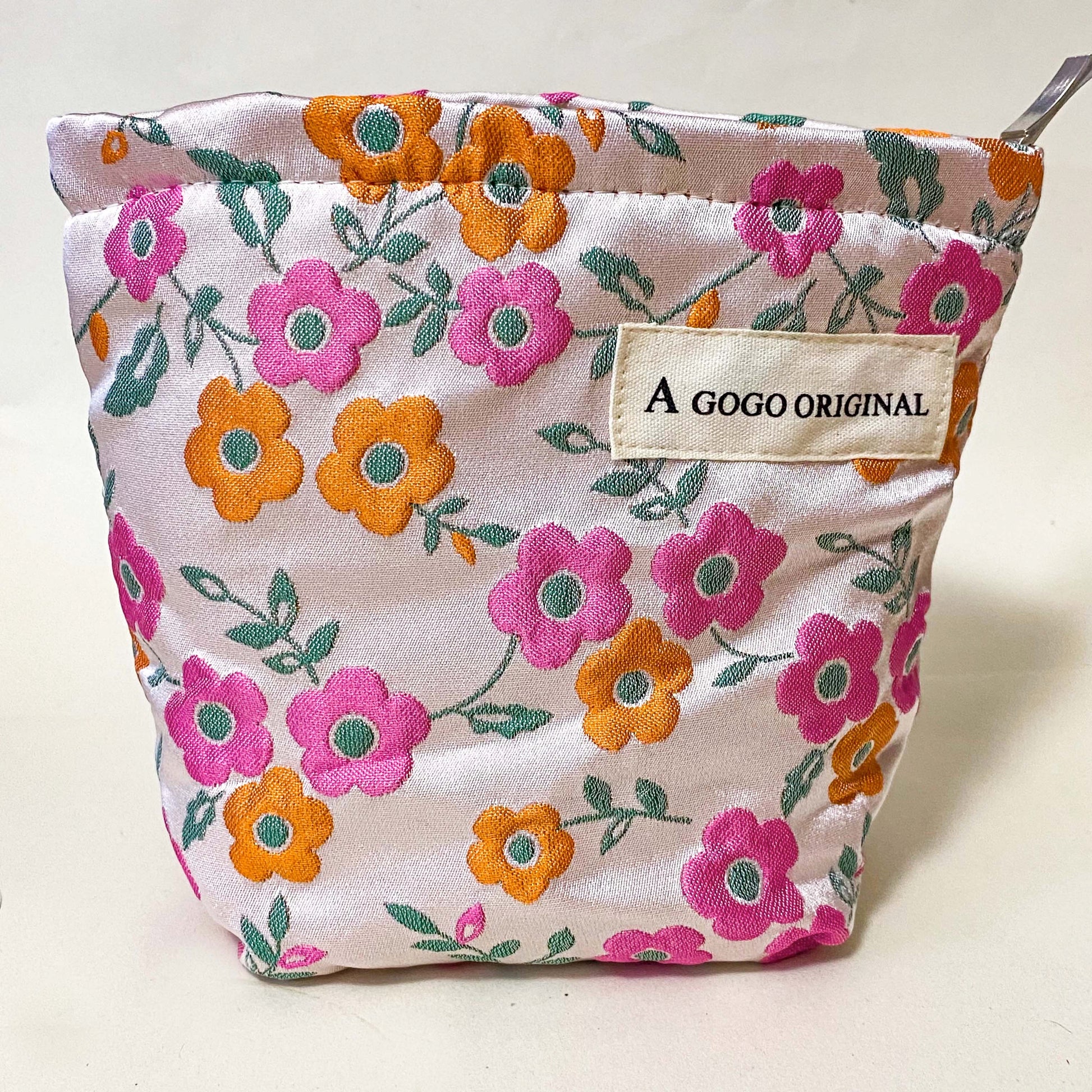 premium woven retro blossom lane cosmetic pouch with pink and coral orange floral design, cream lining and concealed zip. Small bucket shape make up bag. uk letterbox gifts for flower lovers.