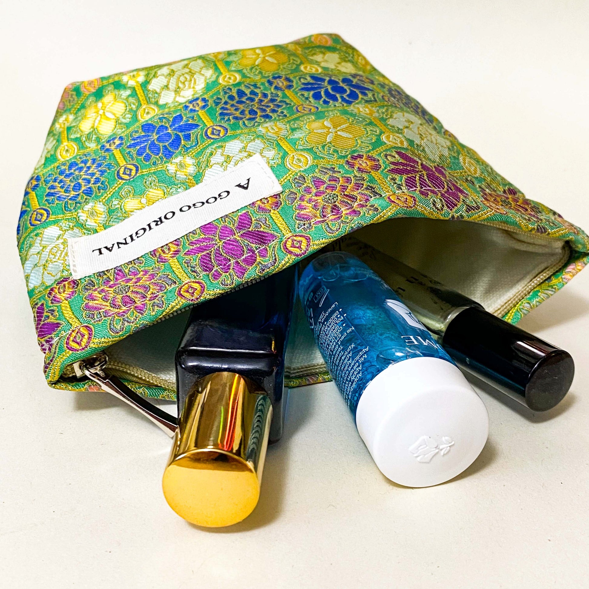 premium woven brocade cosmetic pouch in jade green with intricate mosaic inspired pattern in blue, purple, antique gold and cream. Fully lined with concealed zip. UK letterbox gifts shop. Small ornate fabric make up bag. 