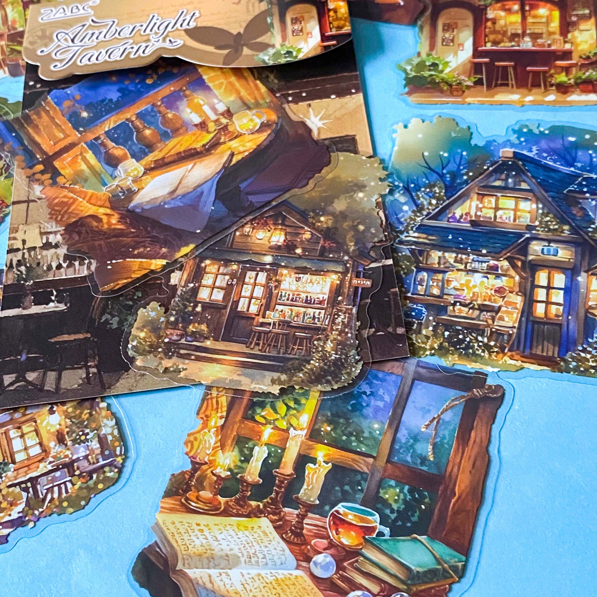 hidden worlds amberlight tavern cosy fantasy large plastic stickers set with candlelit rooms, woodland cottages and warm glowing tavern scenes