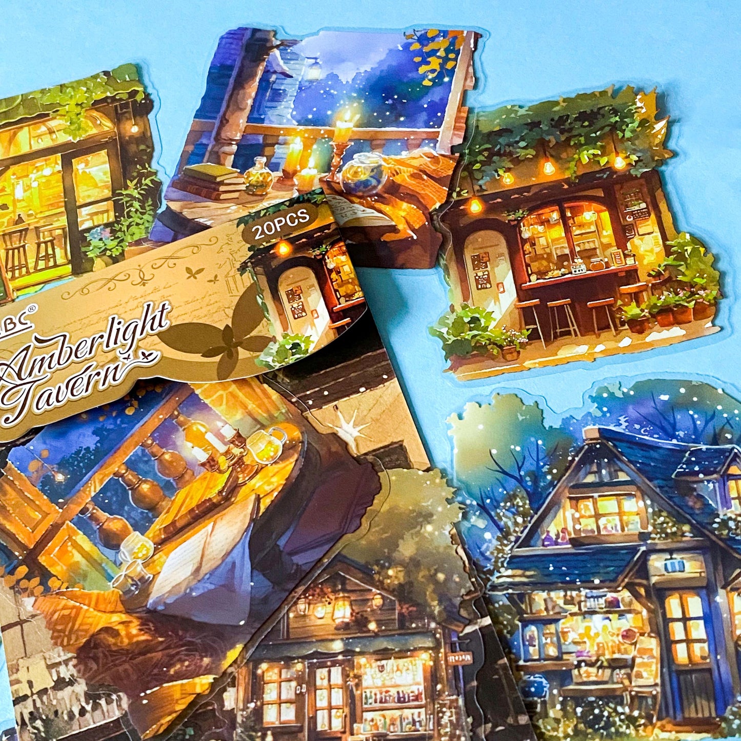 hidden worlds amberlight tavern cosy fantasy large plastic stickers set with candlelit rooms, woodland cottages and warm glowing tavern scenes