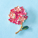 Floral brooch with pink and red hydrangea flowers on a light blue background