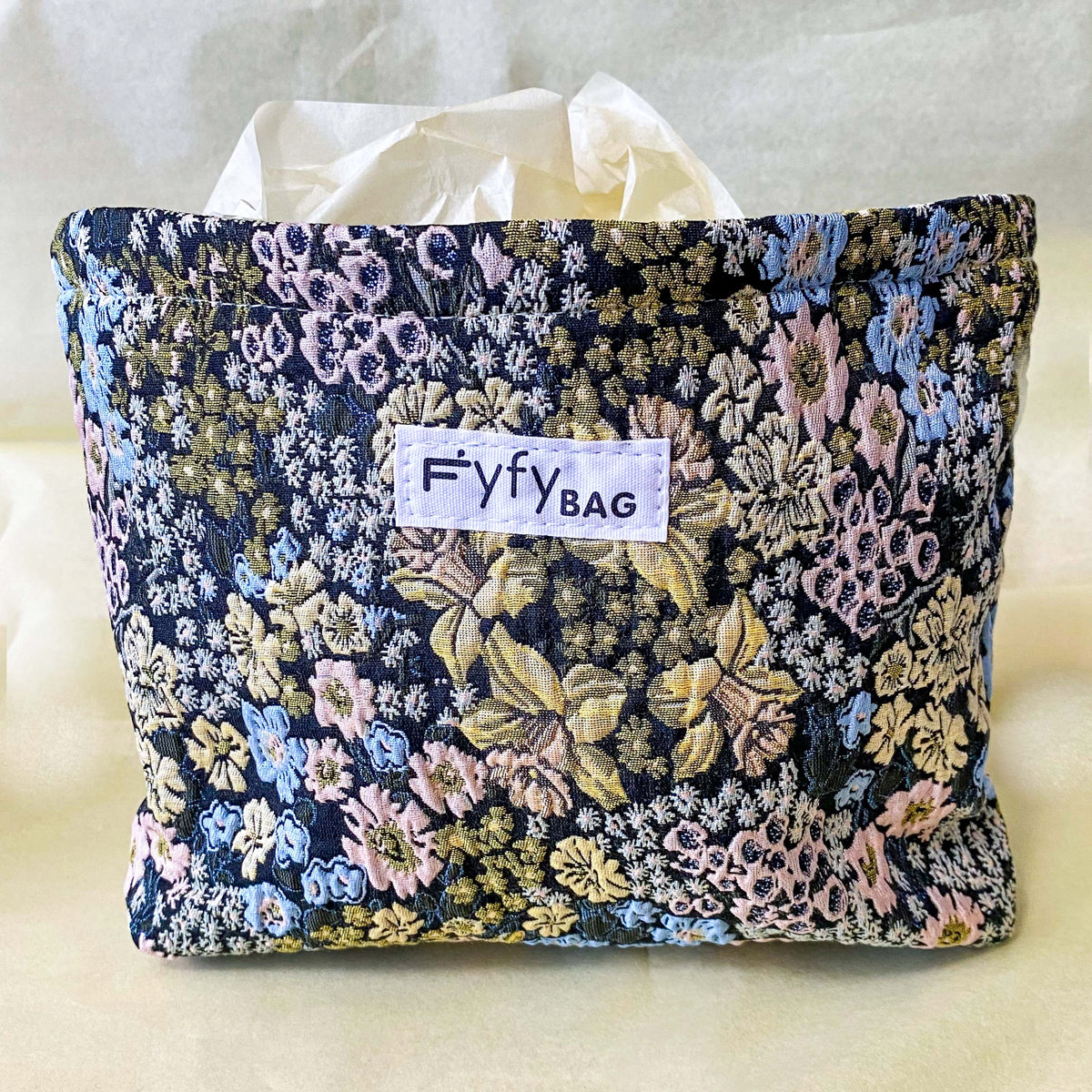 beautiful woven floral tapestry pouch with cream lining, concealed zip- finish and gusseted base. English garden at twilight themed pattern with daffodils, foxgloves, blue pink and yellow flowers. Perfect for cosmetics, stationery and everyday essentials.