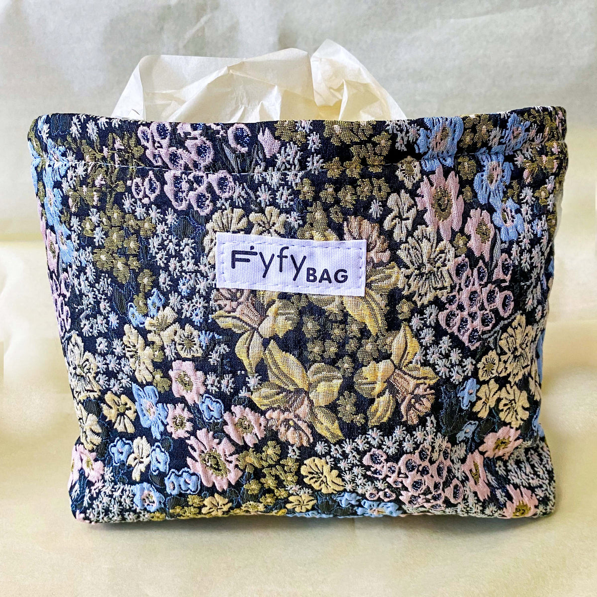 beautiful woven floral tapestry pouch with cream lining, concealed zip- finish and gusseted base. English garden at twilight themed pattern with daffodils, foxgloves, blue pink and yellow flowers. Perfect for cosmetics, stationery and everyday essentials.