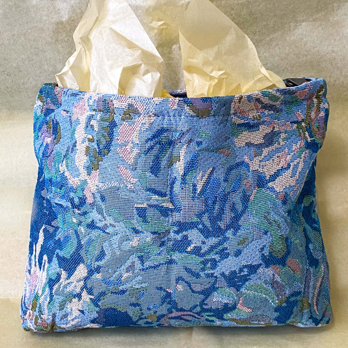 blue, pale pink and turquoise chrysanthemum tapestry pouch with woven floral fabric, cream lining, concealed zip closure and gusseted base. Botanical make up cosmetic pouch, large pencil case or journaling bag. Uk gifts shop. Gifts for flower lovers.