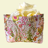 wildflower meadow tapestry pouch with colourful woven floral design including daisies, cream lining, concealed zip closure and gusseted base. Cream, orange, lemon, soft green and white design. Subtle sheen. Large cosmetic bag or toiletry pouch. Uk botanical gift shop.