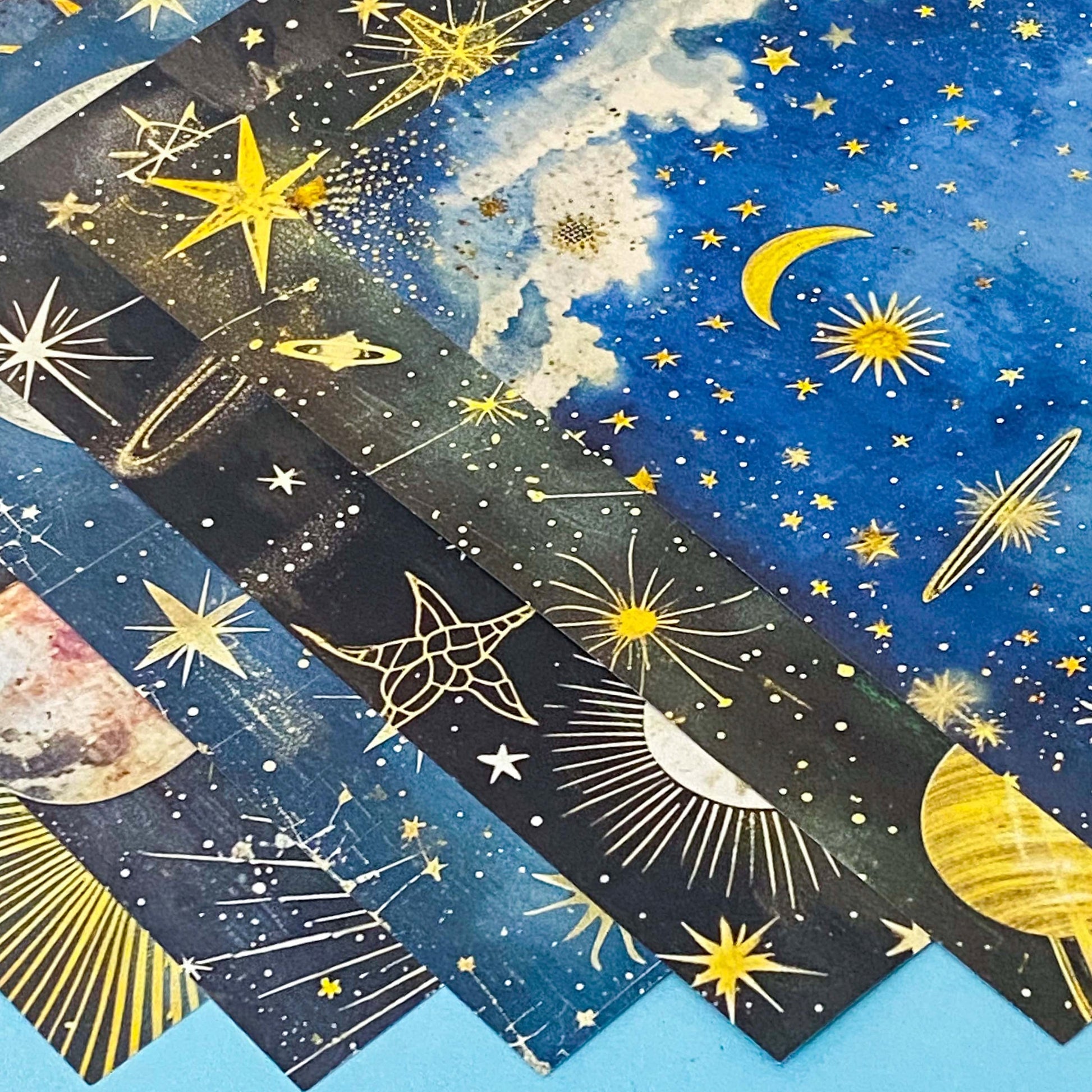 celestial scrapbook paper pack with dark blue sky night designs featuring gold stars, moons, planets and vintage astrology illustrations