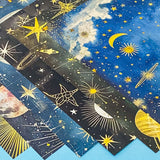 celestial scrapbook paper pack with dark blue sky night designs featuring gold stars, moons, planets and vintage astrology illustrations