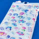 close up of plastic domed kawaii stickers with blue and pink hearts, bows, clouds and flowers