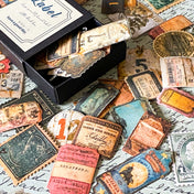 vintage label sticker box slightly open showing small matte ephemera stickers inside on handwritten background