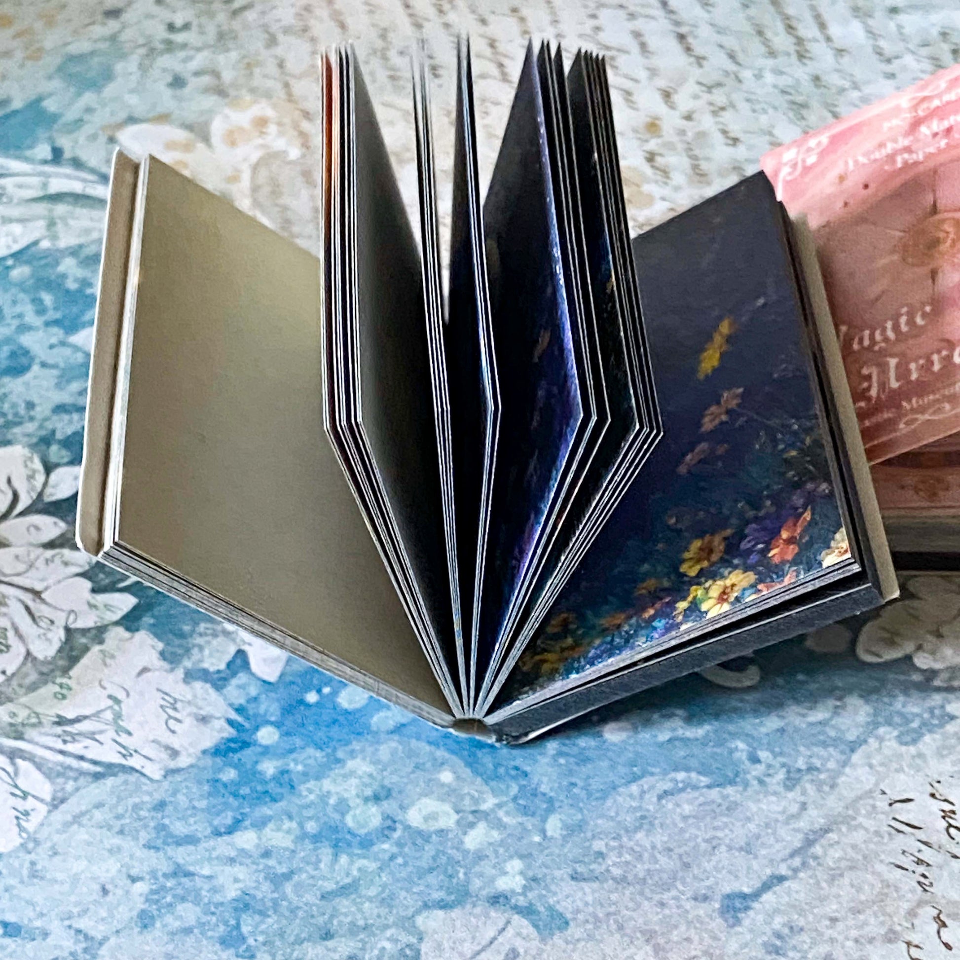 two miniature vintage style scrapbooking vellum and paper books, interstellar object and magic star array, with celestial themed covers