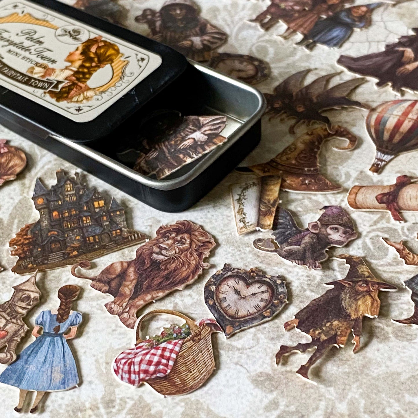 wizard of Oz card stickers in a mini tin featuring vintage style illustrations of dorothy, the lion, flying monkey, tin man and witch