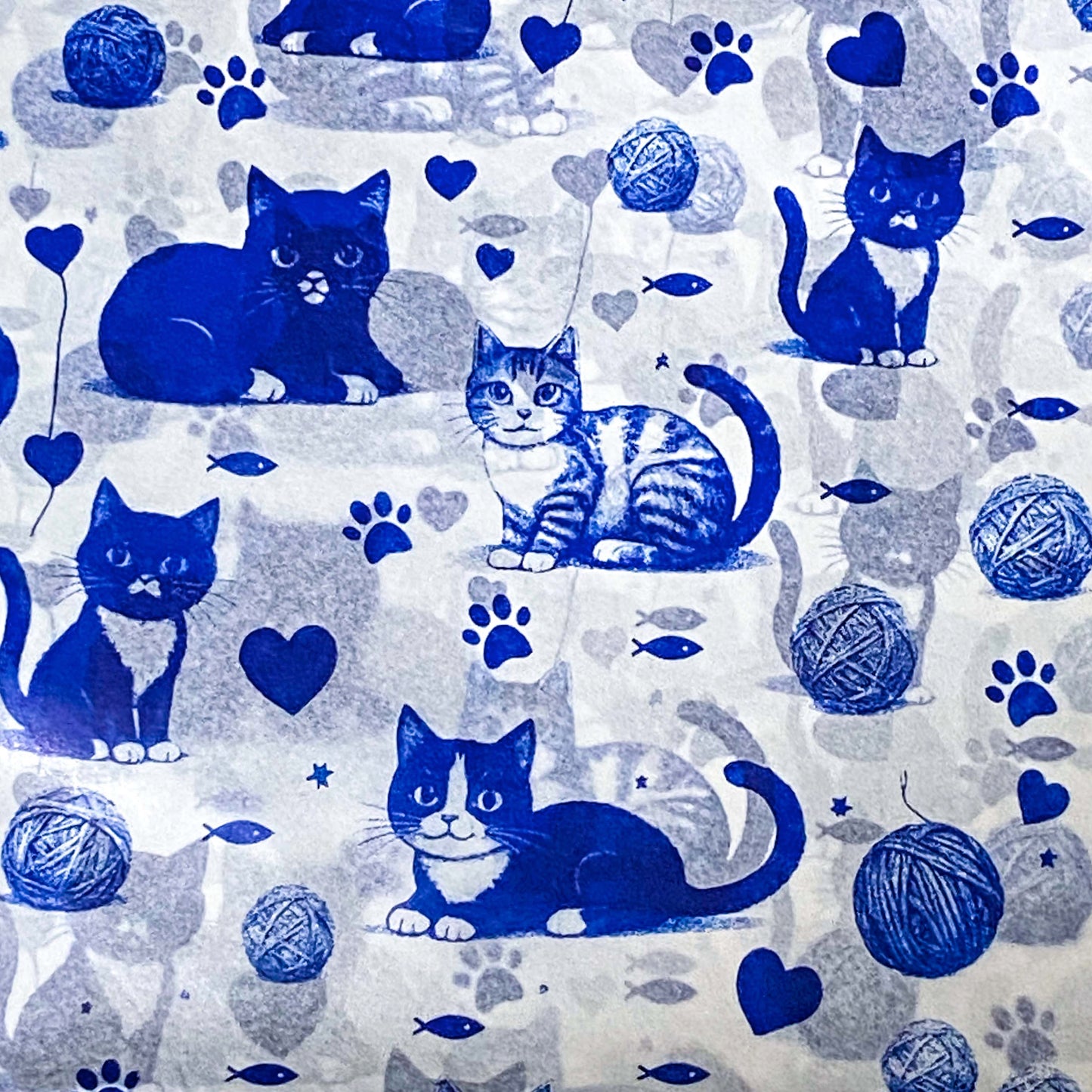 tissue paper with a Pattern of blue cats, yarn balls, and paw prints on a light background
