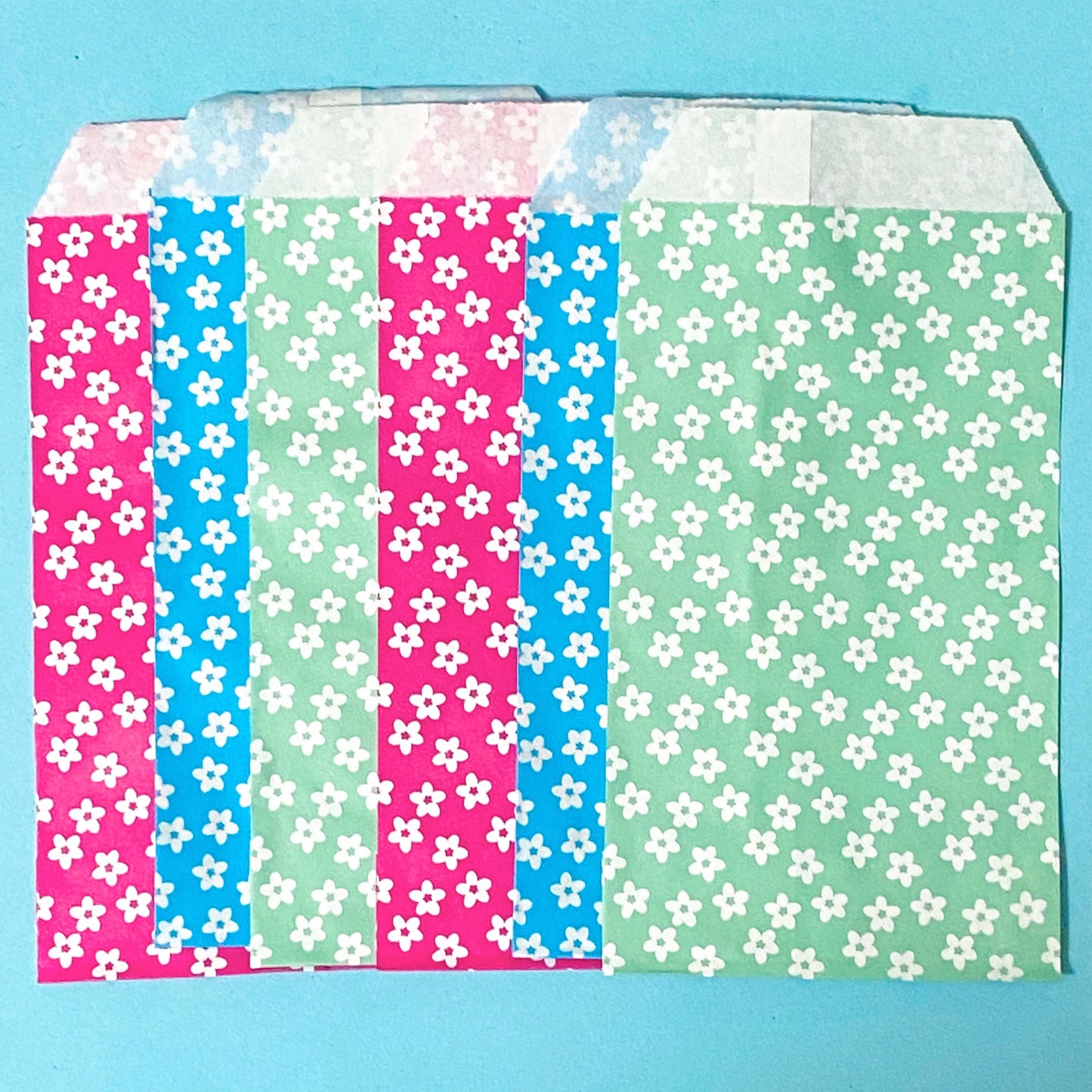 colourful paper bags with floral daisy patterns on a blue background