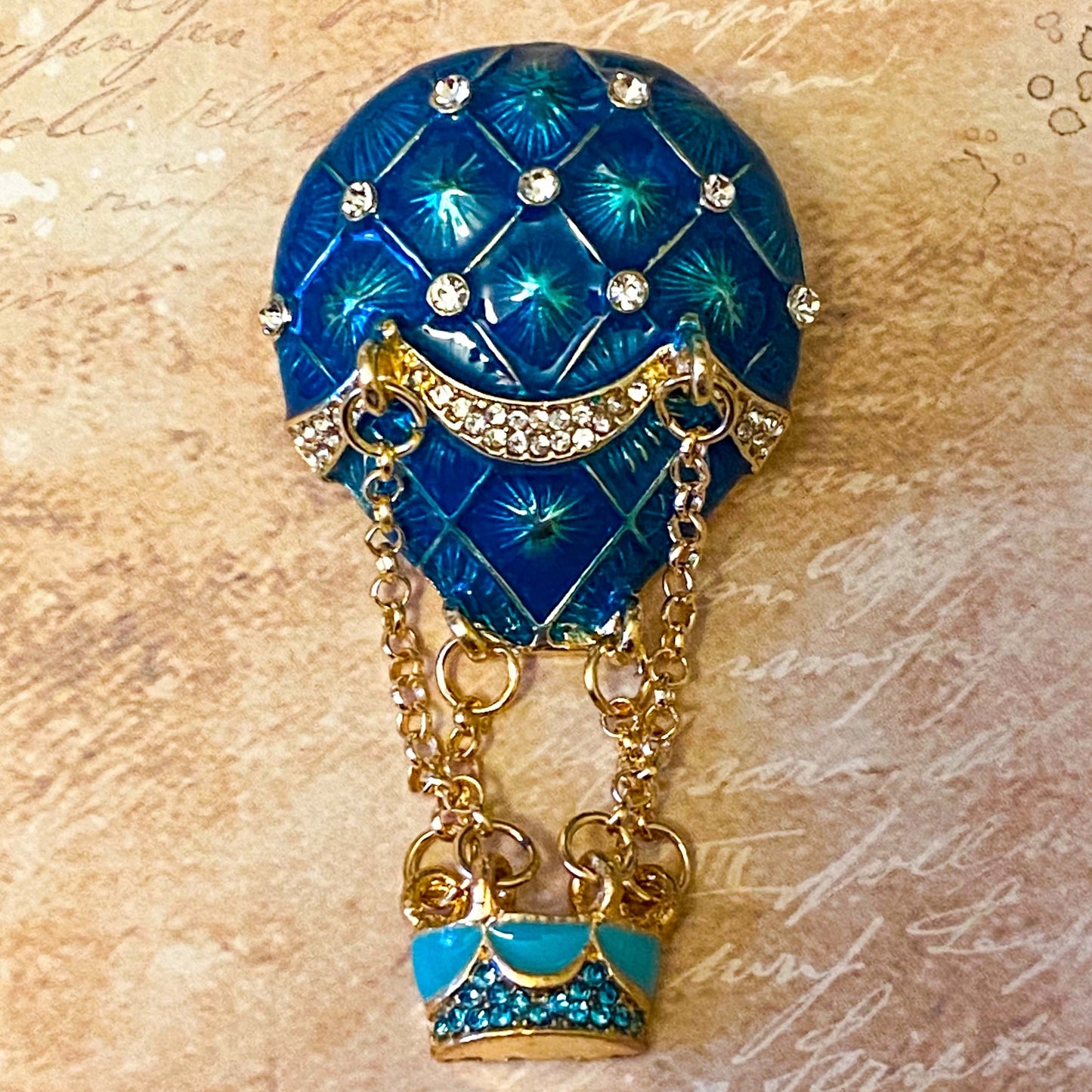 statement vintage style hot air balloon gold brooch with hanging basket and teal blue enamel