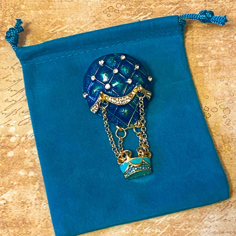 hot air balloon enamel and rhinestone brooch on a velvet bag