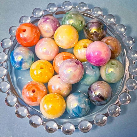 Colorful marbled 16mm acrylic beads in a decorative glass dish on a blue background
