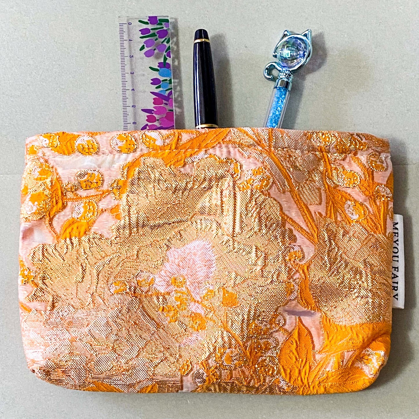 peaches and cream warm orange and gold metallic thread woven tapestry pouch for make up and beauty essentials. fully lined in cream with a concealed zip. floral pattern small fabric cosmetic bag. uk letterbox gifts.