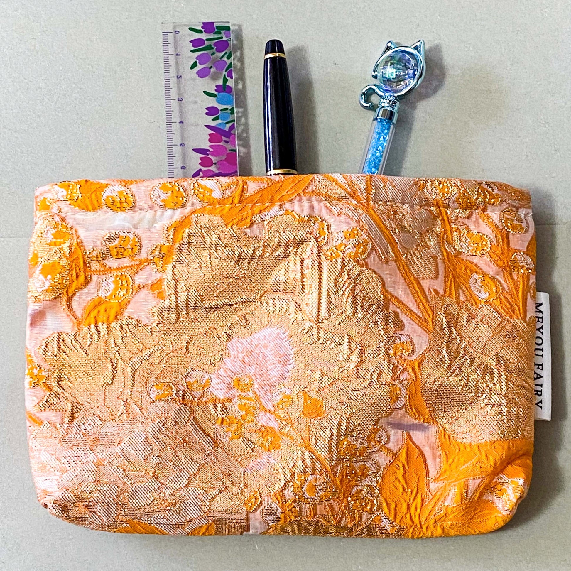 peaches and cream warm orange and gold metallic thread woven tapestry pouch for make up and beauty essentials. fully lined in cream with a concealed zip. floral pattern small fabric cosmetic bag. uk letterbox gifts.