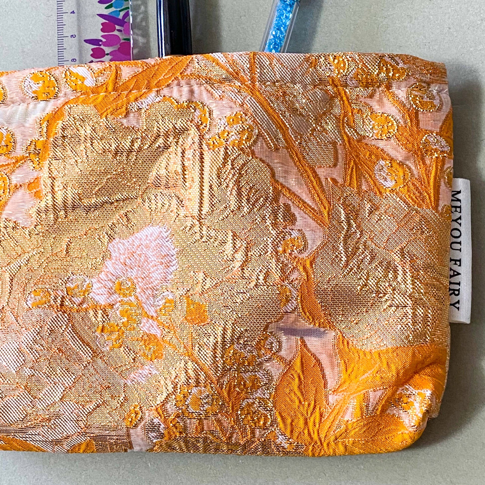 peaches and cream warm orange and gold metallic thread woven tapestry pouch for make up and beauty essentials. fully lined in cream with a concealed zip. floral pattern small fabric cosmetic bag. uk letterbox gifts.