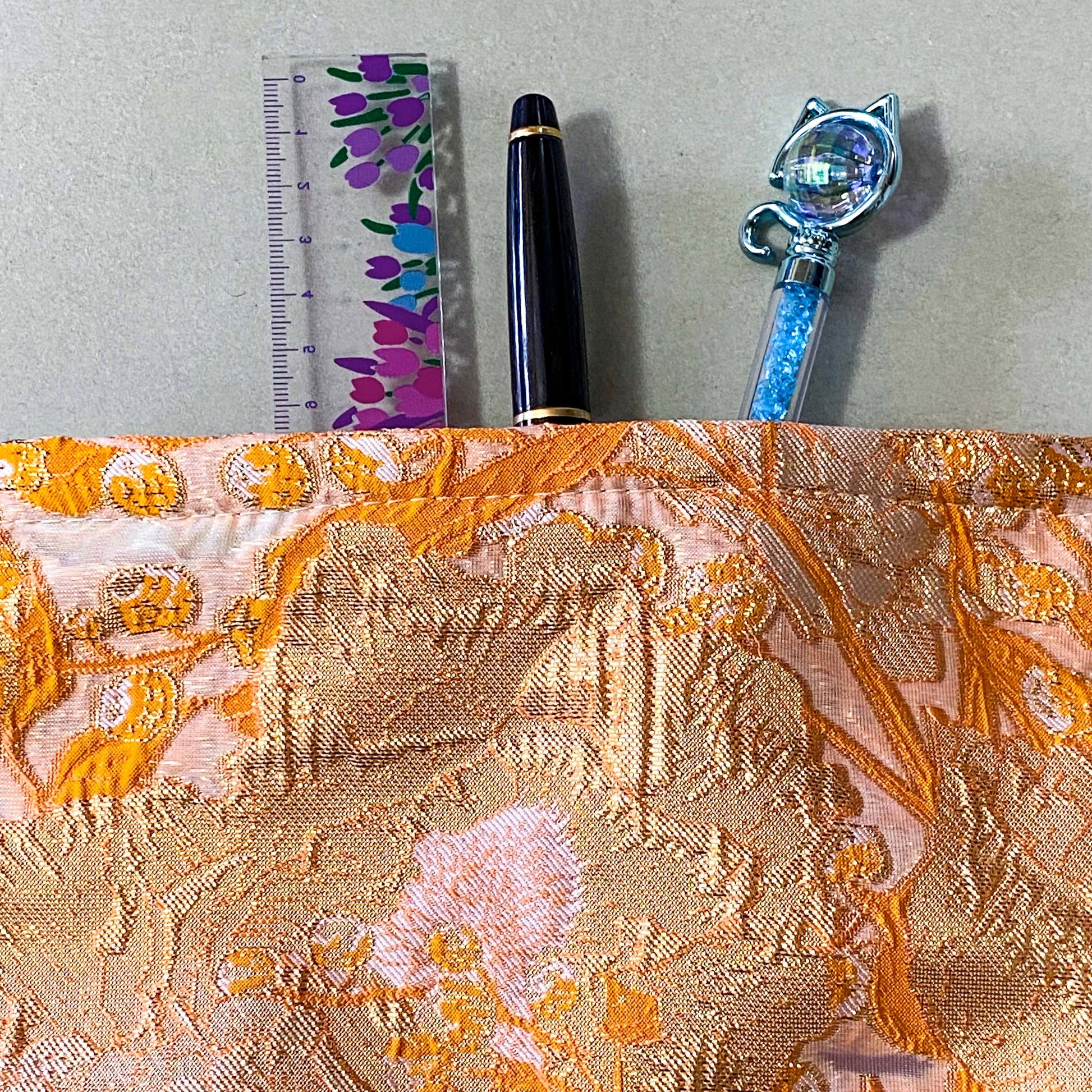 peaches and cream warm orange and gold metallic thread woven tapestry pouch for make up and beauty essentials. fully lined in cream with a concealed zip. floral pattern small fabric cosmetic bag. uk letterbox gifts.