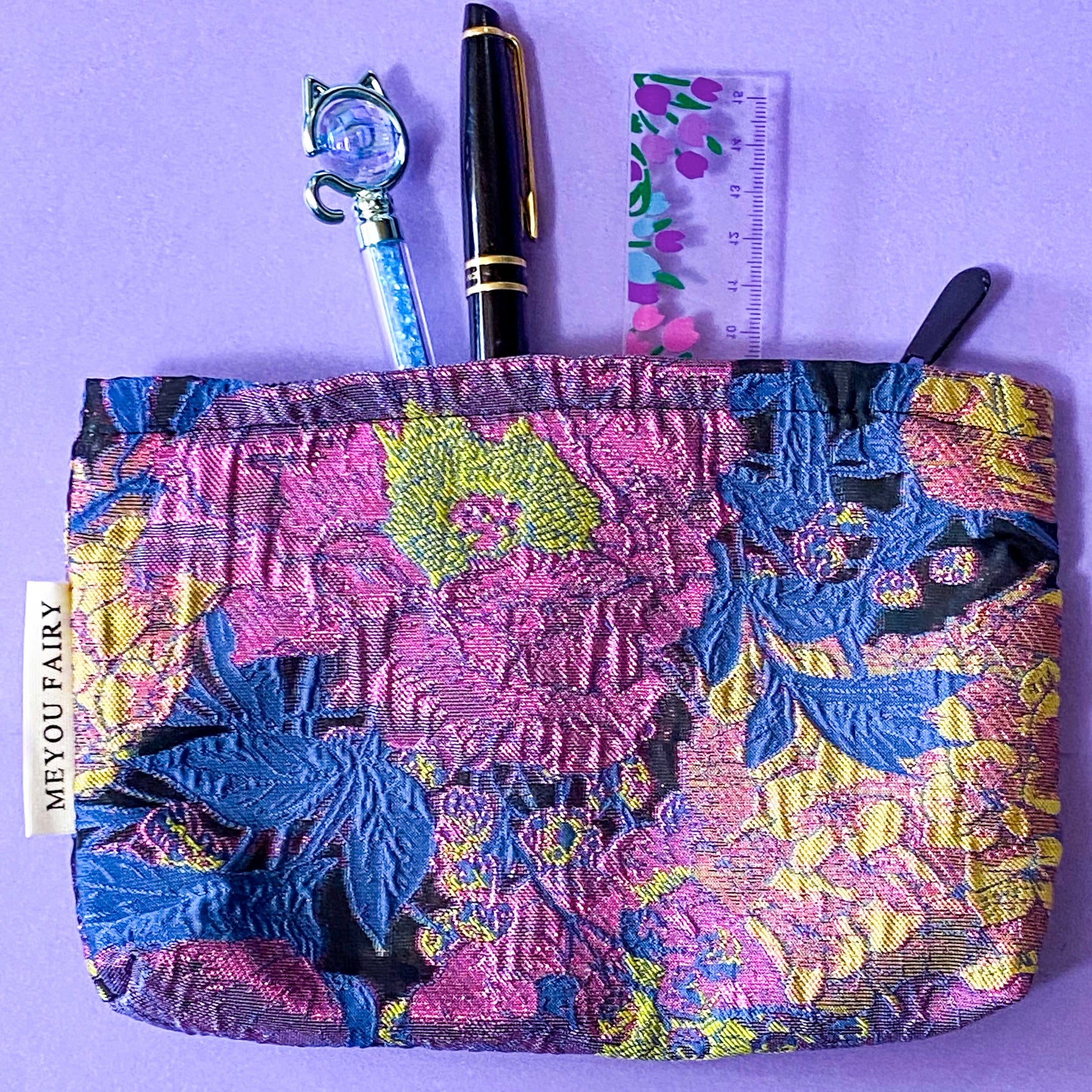 sapphire and magenta twilight luxury woven tapestry cosmetic or jewellery pouch with a sapphire blue botanical leaves and vibrant cerise florals. fully lined in black fabric and finished with a concealed zip.