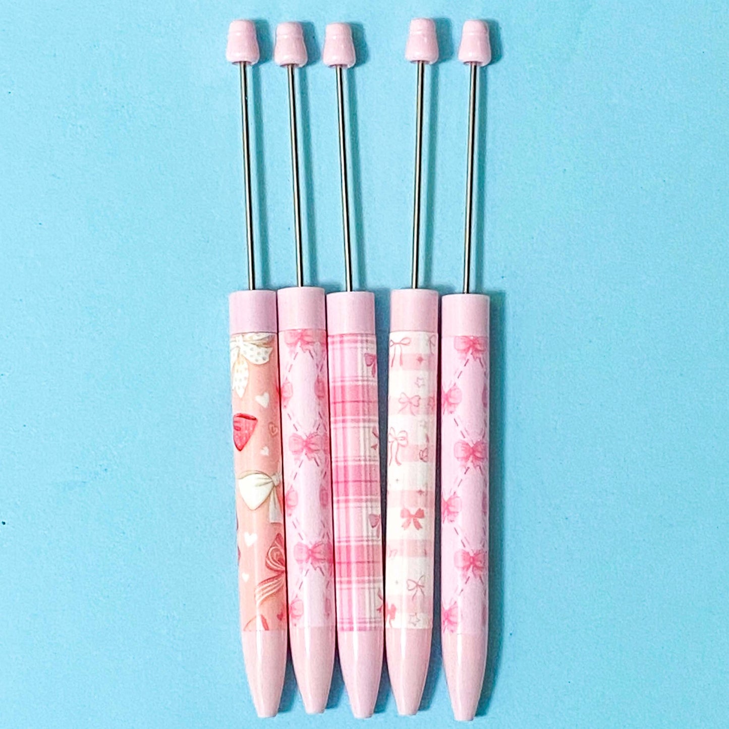 pink and white bow pattern pen blanks on a blue background