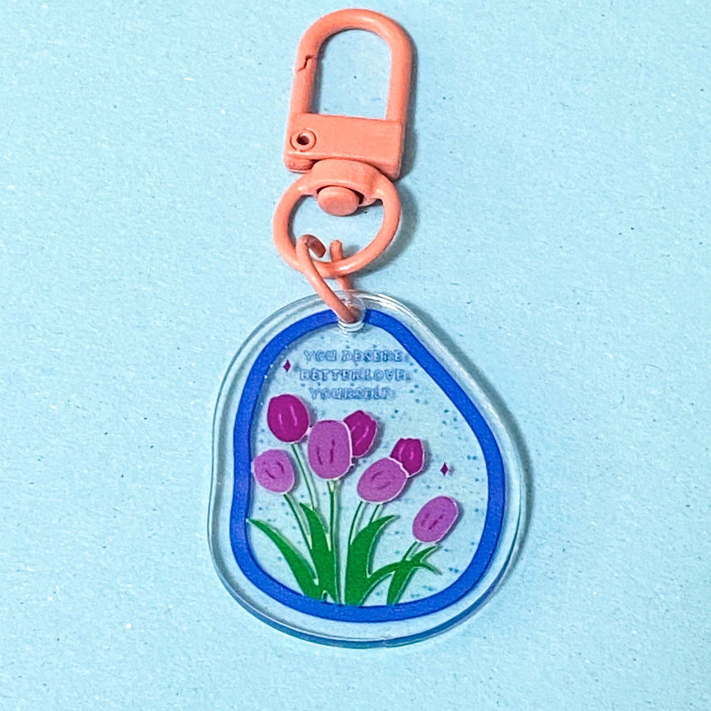 Keychain with pink tulips design on a light blue background