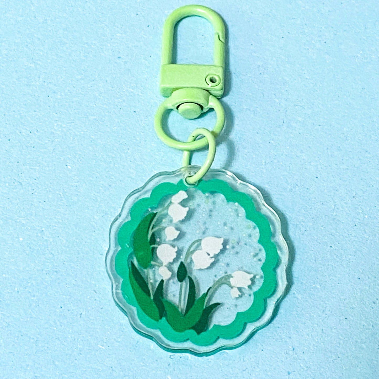 Keychain with  snowdrop floral design on a light blue background