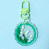 Keychain with  snowdrop floral design on a light blue background