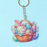acrylic Keychain with a cartoon bunny in a basket on a light blue background
