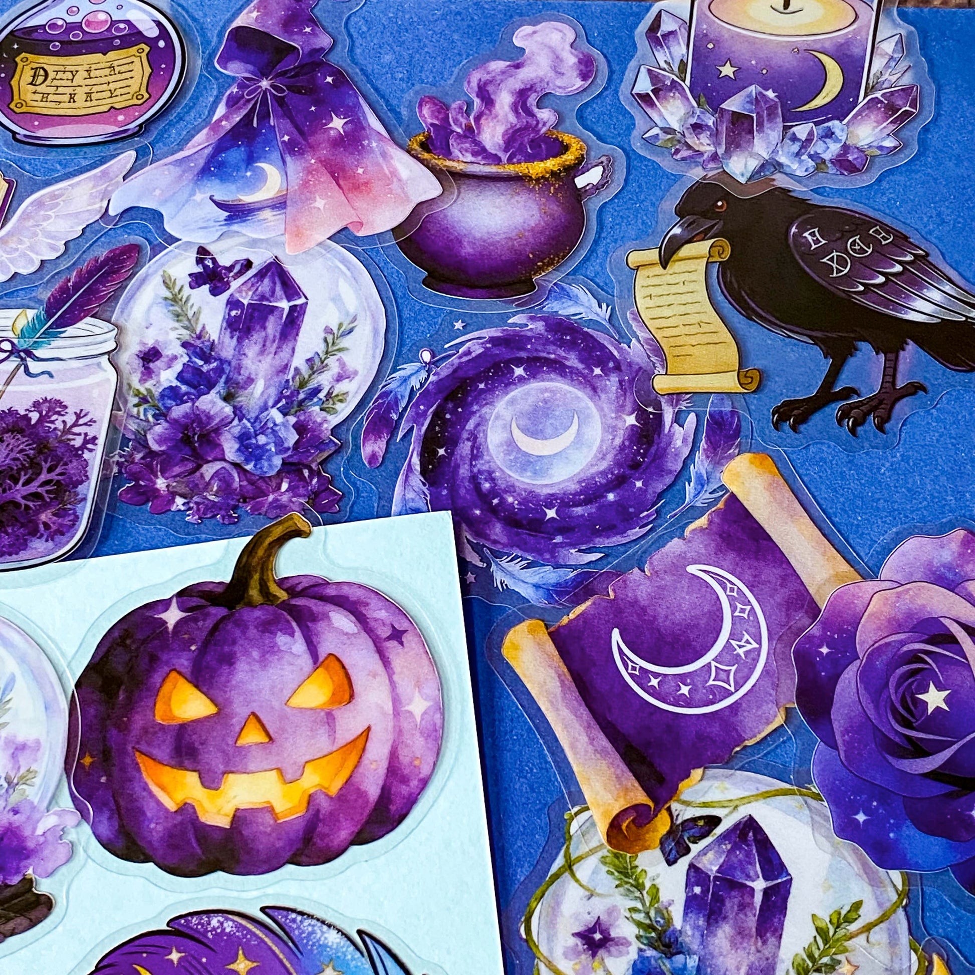 pack of 50 magical fantasy stickers featuring crystal balls, spell books, moonlit scrolls, enchanted mushrooms, ravens, potion bottles, celestial moons, magical animals and crystal gardens in lavender, violet and blue tones. UK stationery shop and letterbox gifts store.