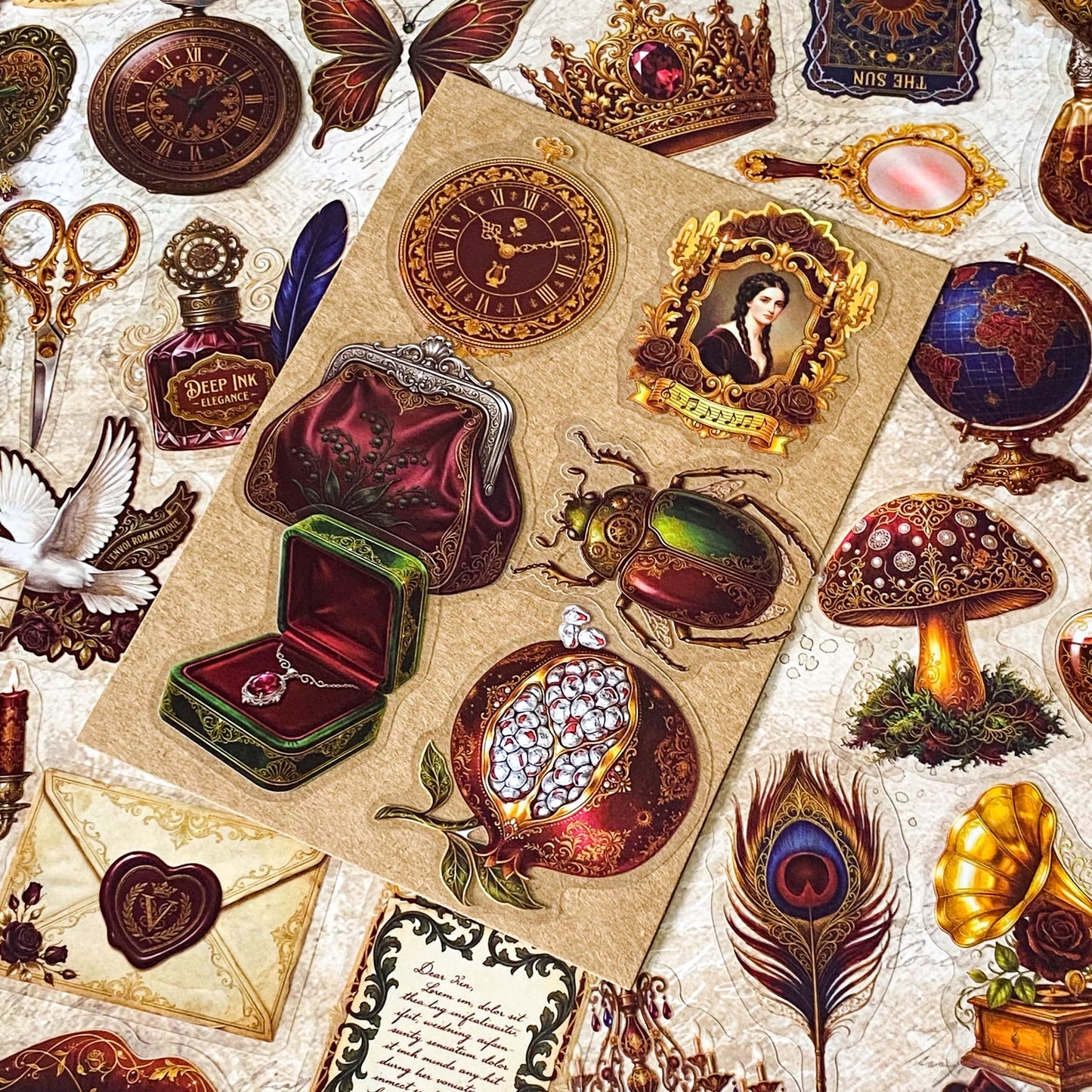 pack of 50 victorian inspired clear PET ephemera stickers featuring antique books, clocks, perfume bottles, roses, swans, butterflies, crowns, handwritten letters and curiosity cabinet treasures in rich dark burgundy, gold, green and midnight blue tones. Uk stationery shop.