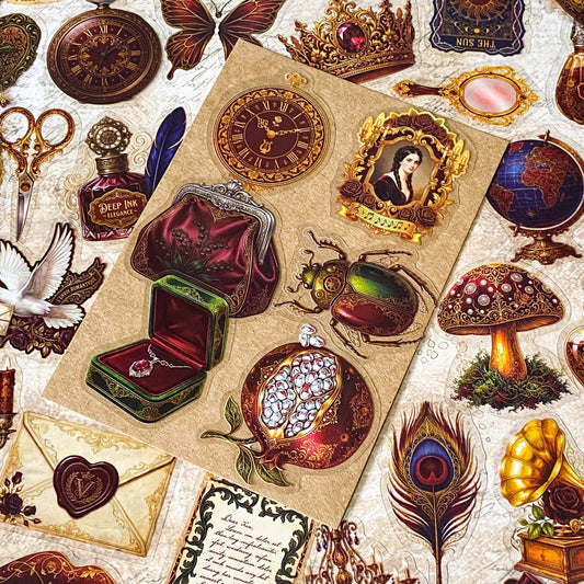pack of 50 victorian inspired clear PET ephemera stickers featuring antique books, clocks, perfume bottles, roses, swans, butterflies, crowns, handwritten letters and curiosity cabinet treasures in rich dark burgundy, gold, green and midnight blue tones. Uk stationery shop.