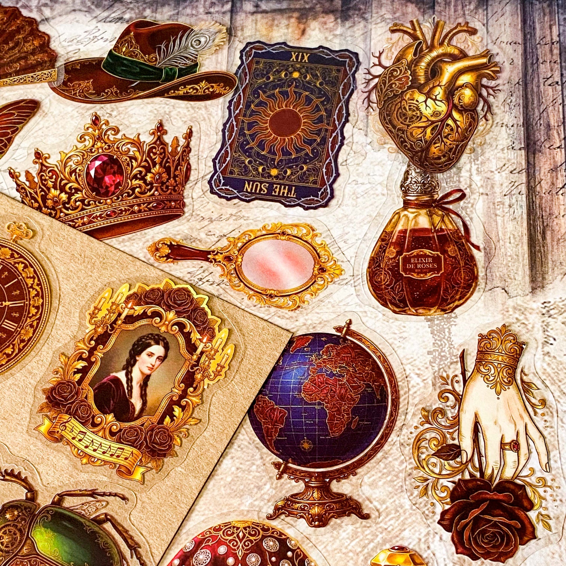 pack of 50 victorian inspired clear PET ephemera stickers featuring antique books, clocks, perfume bottles, roses, swans, butterflies, crowns, handwritten letters and curiosity cabinet treasures in rich dark burgundy, gold, green and midnight blue tones. Uk stationery shop.