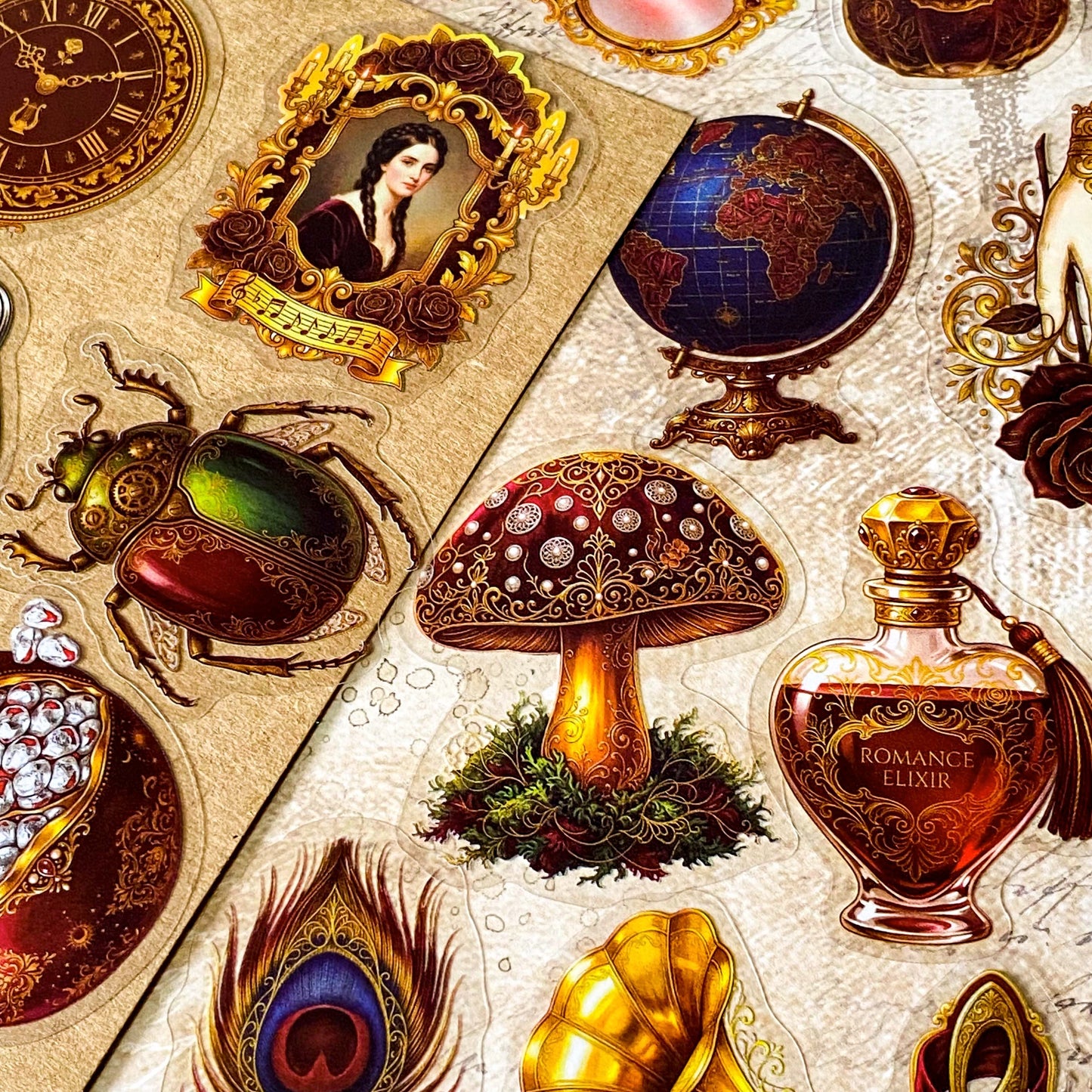 pack of 50 victorian inspired clear PET ephemera stickers featuring antique books, clocks, perfume bottles, roses, swans, butterflies, crowns, handwritten letters and curiosity cabinet treasures in rich dark burgundy, gold, green and midnight blue tones. Uk stationery shop.