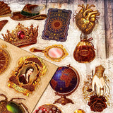 pack of 50 victorian inspired clear PET ephemera stickers featuring antique books, clocks, perfume bottles, roses, swans, butterflies, crowns, handwritten letters and curiosity cabinet treasures in rich dark burgundy, gold, green and midnight blue tones. Uk stationery shop.
