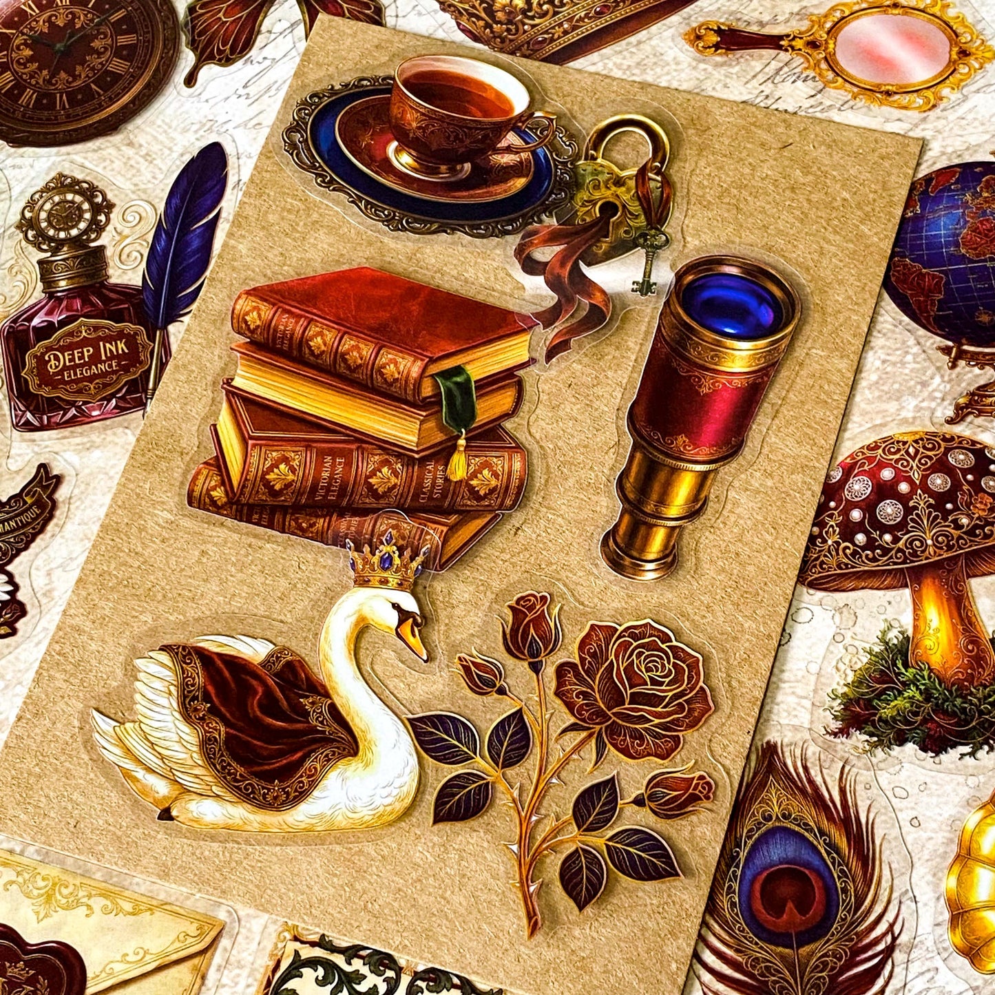 pack of 50 victorian inspired clear PET ephemera stickers featuring antique books, clocks, perfume bottles, roses, swans, butterflies, crowns, handwritten letters and curiosity cabinet treasures in rich dark burgundy, gold, green and midnight blue tones. Uk stationery shop.