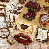 pack of 50 victorian inspired clear PET ephemera stickers featuring antique books, clocks, perfume bottles, roses, swans, butterflies, crowns, handwritten letters and curiosity cabinet treasures in rich dark burgundy, gold, green and midnight blue tones. Uk stationery shop.