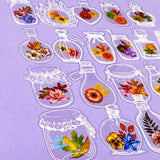 Decorative clear plastic pet stickers of flowers in glass jars on a purple background