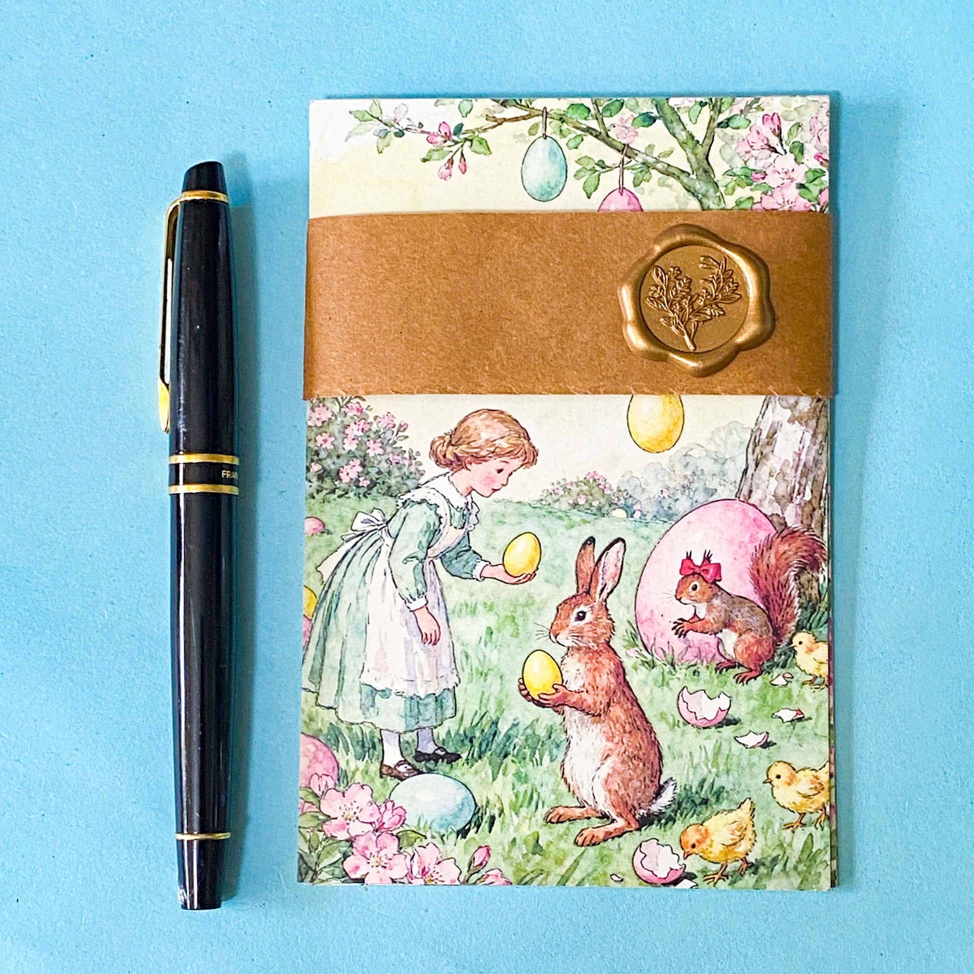 vintage storybook postcard set of 5 wrapped in a kraft belly band with wax seal on a blue background